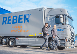 Ein LKW mit zwei Mitarbeitern der Reber Logistik - Unser Kunde für Markenbildung