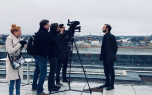 4 Menschen hinter der Kamera filmen einem Mann vor der Kamera während des DER Touristik Imagefilms