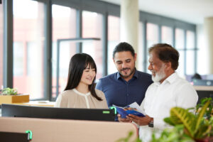 Kampagnenmotiv: Drei Kolleg:innen von Mitsui Chemicals Europe betrachten gemeinsam Unterlagen im Büro.